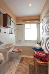 波茨坦Wohnung mit Blick über Potsdam的浴室配有盥洗盆、卫生间和浴缸。
