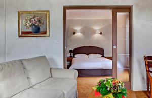 塞尔河畔维克Hotel Beauséjour的客厅配有床和沙发