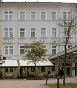 开姆尼茨萨彻瑟斯查尔酒店的前面有一棵树的白色大建筑