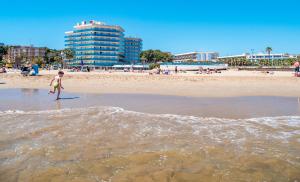 拉皮内达多内尔海滩黄金酒店的站在海滩水面上的小孩