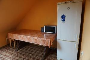 塔尔西Kamparkalns的客房内的桌子配有微波炉和冰箱