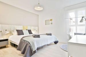萨拉戈萨Mirador del Ebro的白色卧室设有床铺和水槽