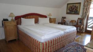 Au an der DonauGasthof Jaegerwirt的一间卧室配有一张红色和白色条纹的大床