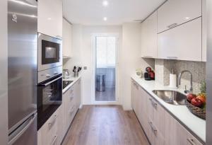 马贝拉马贝拉豪华公寓 的白色的厨房配有水槽和冰箱