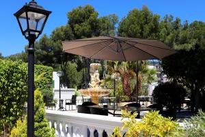 帕格拉哥伦布别墅家庭精品酒店的一个带喷泉和遮阳伞的庭院