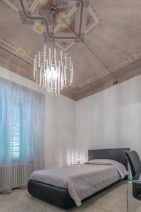 比萨雷莱斯天堂住宿加早餐酒店的一间卧室配有一张床和一个吊灯