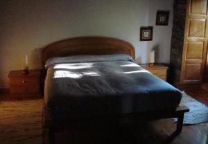DoncosCasa dos Pedrouzos的一间卧室配有一张带木制床头板的床