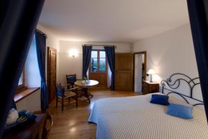 洛达诺卡塞拉菲纳旅馆的卧室配有一张床和一张桌子及椅子