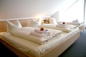 HohenpoldingGasthaus zur Linde的三张床,上面有毛巾和水果