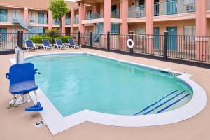 Clute克鲁特美国最佳价值汽车旅馆的一个带蓝色椅子的酒店游泳池