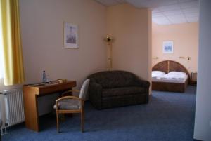 黑森奥尔登多夫威悉河巴克斯曼沃希拜顿酒店的酒店客房配有椅子、书桌和床。
