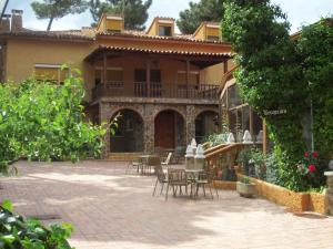 昆卡La Villa Don Quijote的庭院内带桌椅的房子