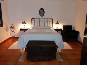 米尔芳提斯城Casa das Hortências By Alojamentos Vitinho - Vila Nova MIlfontes的一间卧室配有一张床、两盏灯和一把椅子