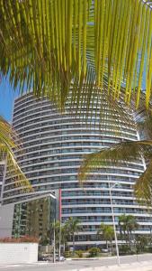 福塔莱萨Apart-Hotel Terraços do Atlântico的一座大建筑,前面有棕榈树