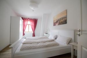 路德斯塔德·威特比Ferienwohnungen EULE的白色的卧室设有白色的床和窗户。