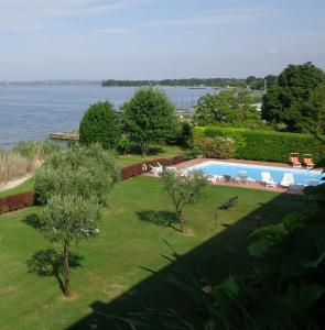 西尔米奥奈Appartamento ORCHIDEA a Sirmione sul Lago di Garda con piscina, giardino e spiaggia con molo的享有游泳池和水景