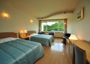 高崎榛名湖温泉日式旅馆的酒店客房设有两张床和窗户。