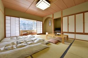 高崎榛名湖温泉日式旅馆的一张大床,位于带大窗户的房间里