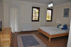 Rubik马鲁布酒店的一间卧室设有一张床和两个窗户。
