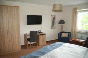 沙尔肯梅伦马尔布里克酒店的一间卧室配有一张床、一张书桌和一台电视