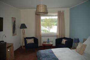 沙尔肯梅伦马尔布里克酒店的一间卧室配有一张床、两把椅子和一个窗户