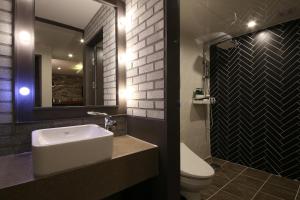 昌原市芝加哥酒店的一间带水槽、卫生间和镜子的浴室