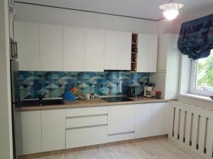 克卢日-纳波卡Apartament Verde的厨房配有白色橱柜和蓝色瓷砖墙壁