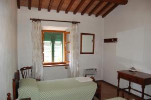 卡沃马里尼奥公寓的一间卧室设有一张床、一个窗口和一张桌子