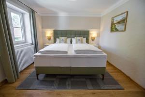 因河畔布劳瑙Schlosstaverne的一张大床,位于带大窗户的房间里