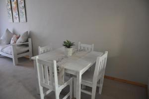 塞吉菲尔德Sedgefield Island Villa的白色的桌子和椅子,上面有盆栽植物