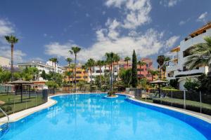 马贝拉马贝拉豪华公寓 的棕榈树和建筑度假村的游泳池