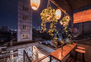 胡志明市喜欢咖啡馆旅舍的阳台配有桌椅和灯