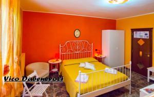 巴列塔B&B Eraclio Suite的一间卧室设有黄色的床和橙色的墙壁