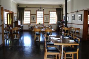 塞雷斯The Hamlet Country Lodge的餐厅设有木桌、椅子和窗户。