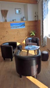 圣雷热雷梅累兹柳莺酒店的客厅配有两张真皮座椅和一张桌子