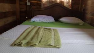 锡吉里亚锡吉里森林景观度假村的一张带绿毯和两个枕头的床