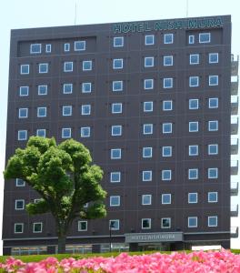 富士市西村酒店的一座建筑前有树的酒店