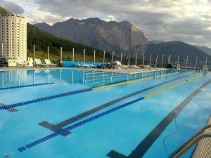 塞斯特雷苏德欧维斯特酒店的一个大型蓝色游泳池,后面是群山