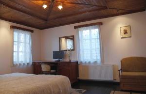 特里亚夫纳爱特姆咖麟酒店的一间卧室配有一张床和一张带镜子的书桌