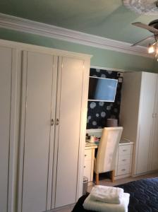 普里茅斯Alma Lodge Guest House的客房设有衣柜、书桌和椅子