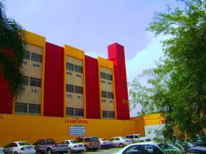 蒙特雷勒噶尔酒店的黄色和红色的建筑,停车场有车辆停放