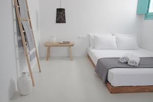 布拉卡Ploes Seaside Houses的白色的卧室,配有床和梯子