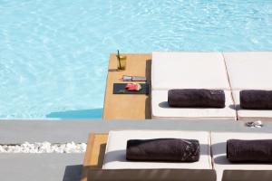 奥诺斯Dreambox Mykonos Suites的游泳池畔的2张白色躺椅