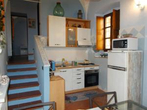 卡萨莱蒙费拉托“La Loggia” Apartment的一间带楼梯和白色冰箱的厨房