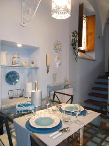 卡萨莱蒙费拉托“La Loggia” Apartment的用餐室配有带盘子和玻璃杯的桌子