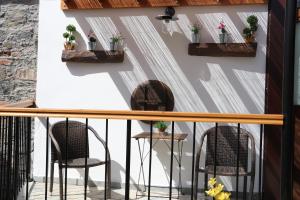 阿格罗斯AgroSpito Traditional Guest House的阳台配有两把椅子,墙上种植了植物