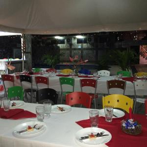 特纳Hotel Joya de la Selva的一间设有白色桌子和五颜六色椅子的用餐室