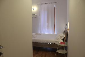 卡利亚里卡利亚里I'MC IoAMo旅馆的一间卧室配有一张带白色窗帘的床