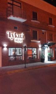 GualeguaychúHotel Tykua的夜间酒店一侧的标志