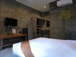 卡农佩斯度假村的一间卧室配有一张床、一张书桌和一台电视